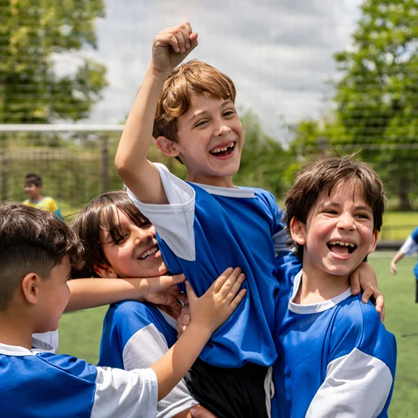 young kids playing soccer and celebrating