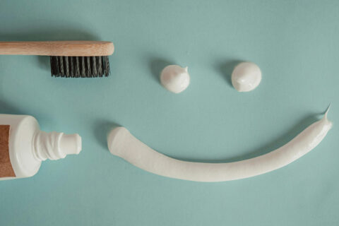 A tooth brush and tooth paste on a table and making a smile with a tooth paste